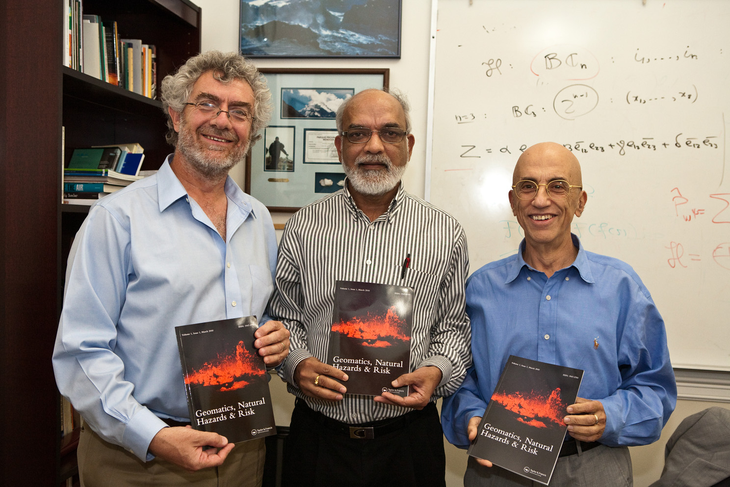 Chancellor Daniele Struppa, Dr. Ramesh Singh and Dr. Menas Kafatos, dean of the Schmid College of Science, show off the new journal edited by Dr. Singh.