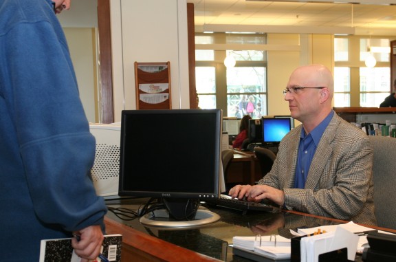 Doug Dechow, Ph.D., sciences librarian, assists a student who stopped by the reference desk for research help. (Photo/David Goto, reference librarian)