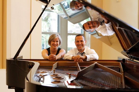 man and woman smiling with piano