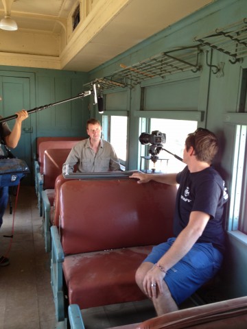 two men on train with video equipment