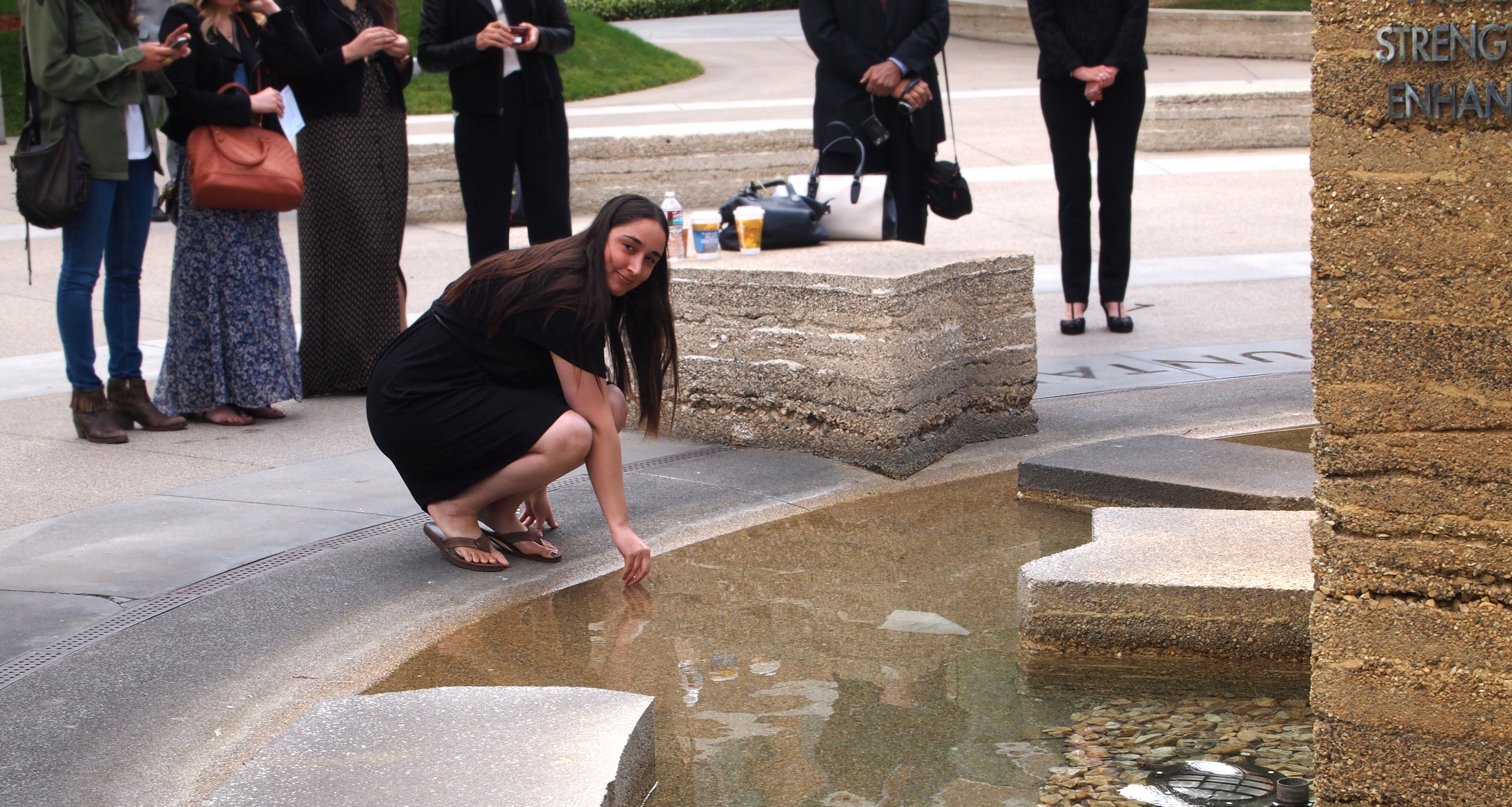 girl dips ring in fountain