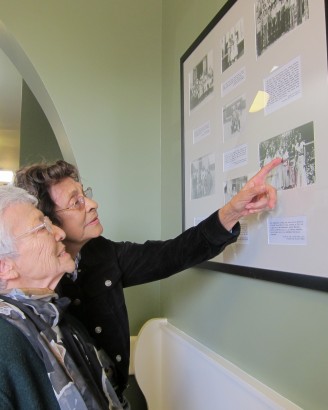 Catalina Figueroa, left, and Emma Cornejo Felix locate family members and friends among the historic photo displays installed in the old Cypress Street School. The women were among several former students who attended ribbon-cutting ceremonies for the new research facility now housed there.