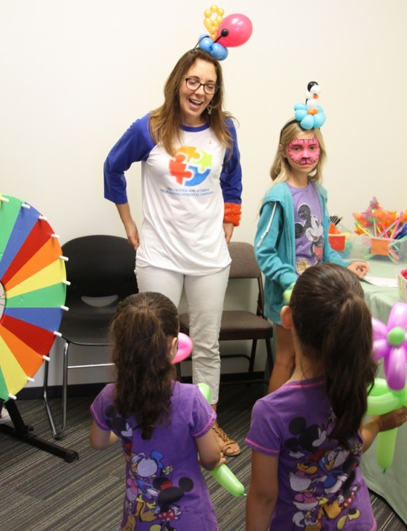 Jeanne Anne Carriere, director of Chapman’s C.A.P. Program for the Center for Autism, greets kids in the face-painting room during the Center’s grand opening May 10.