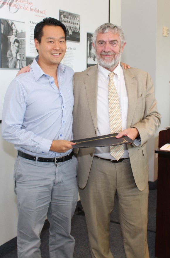 Chancellor Daniele Struppa presents the Senior junior Wang-Fradkin Professorship to Christopher Kim, Ph.D.