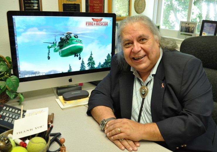 man smiling next to computer