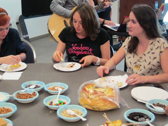 Students enjoy challah bread and decorate apples with sweet toppings during Hillel's Rosh Hashanah party.