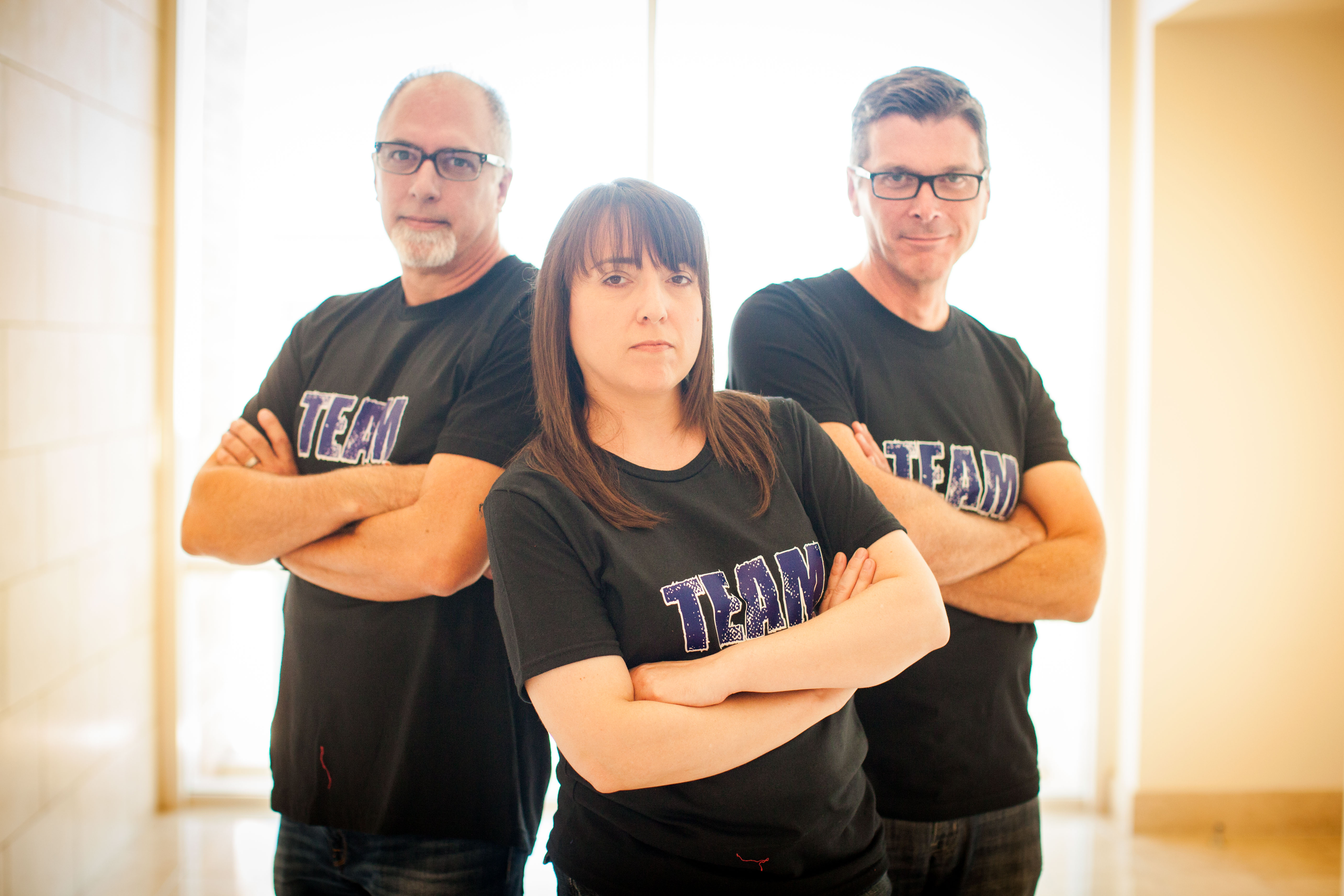 three people with arms crossed