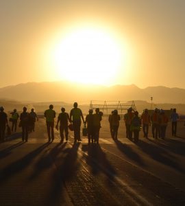 group of people walking into the sunset