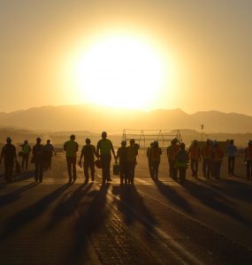 group of people walking into the sunset