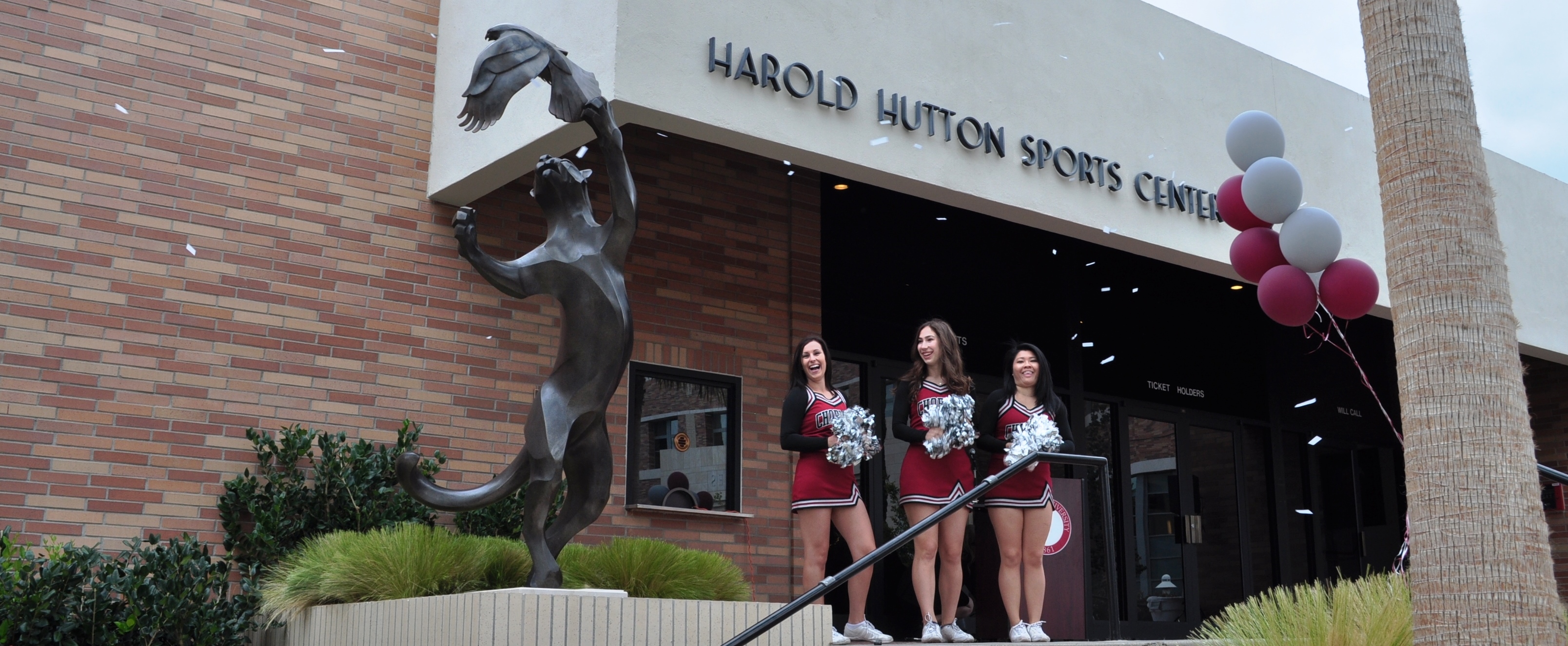 cheerleaders standing by new statue