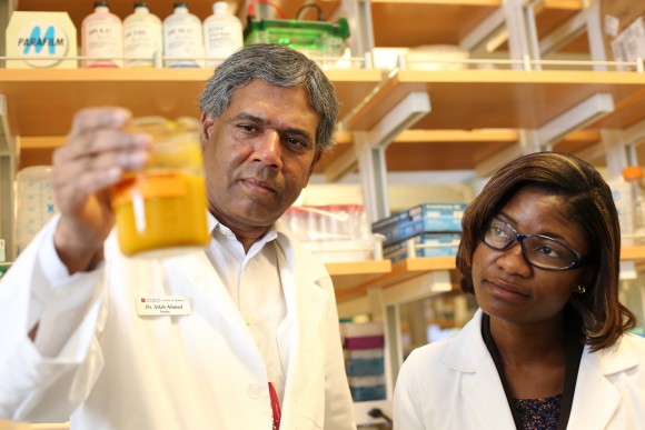 two people looking at a beaker