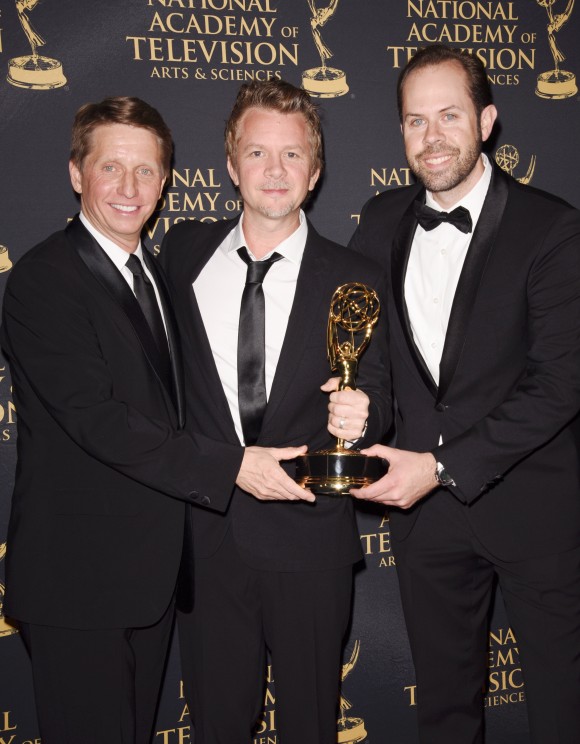 three men holding an award