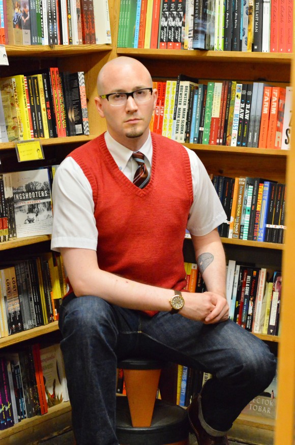 man sitting by books