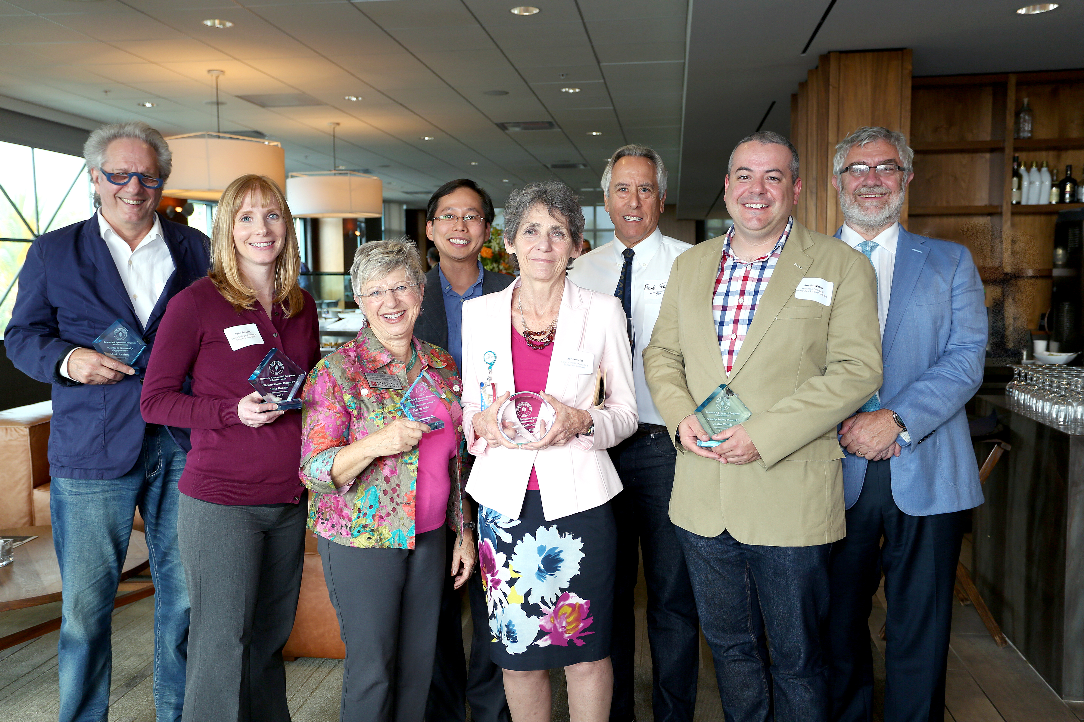 Together at the Faculty Research Recognition Reception are (from left) Mark Axelrod, Julia Boehm, Judy Montgomery (accepting for Kris De Pedro), Miao Zhang, Janeen Hill, Frank Frisch, Justin Walsh and Chancellor Danielle Struppa.