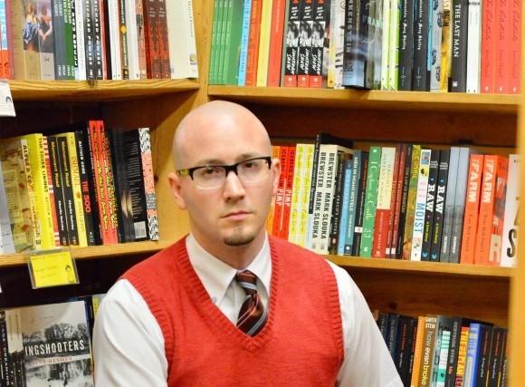 man in front of book shelf