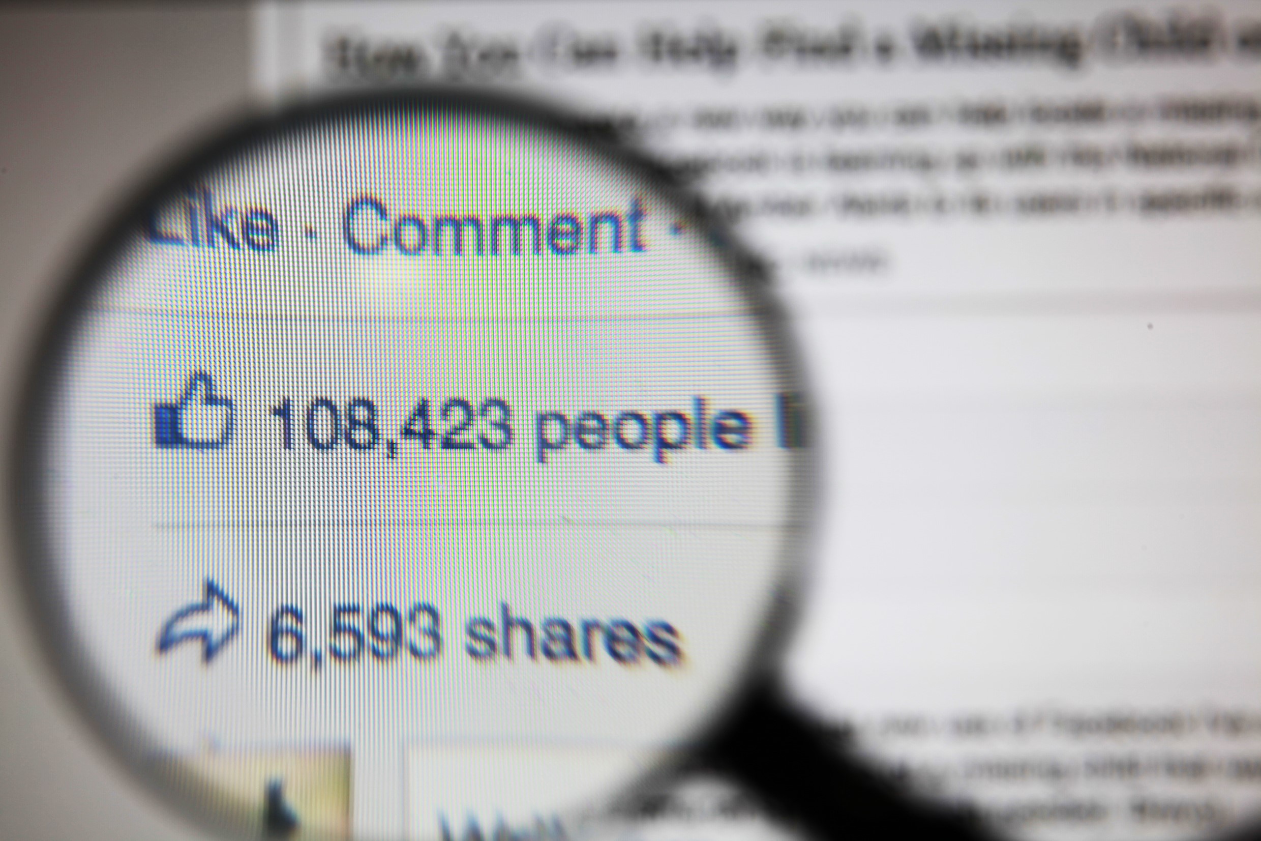 magnifying glass view of facebook post likes and comments