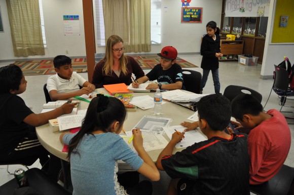 Chapman integrated educational studies major Carley Waterbury '17 guides a table of middle school students through a variety of homework assignments at The Friendly Center.