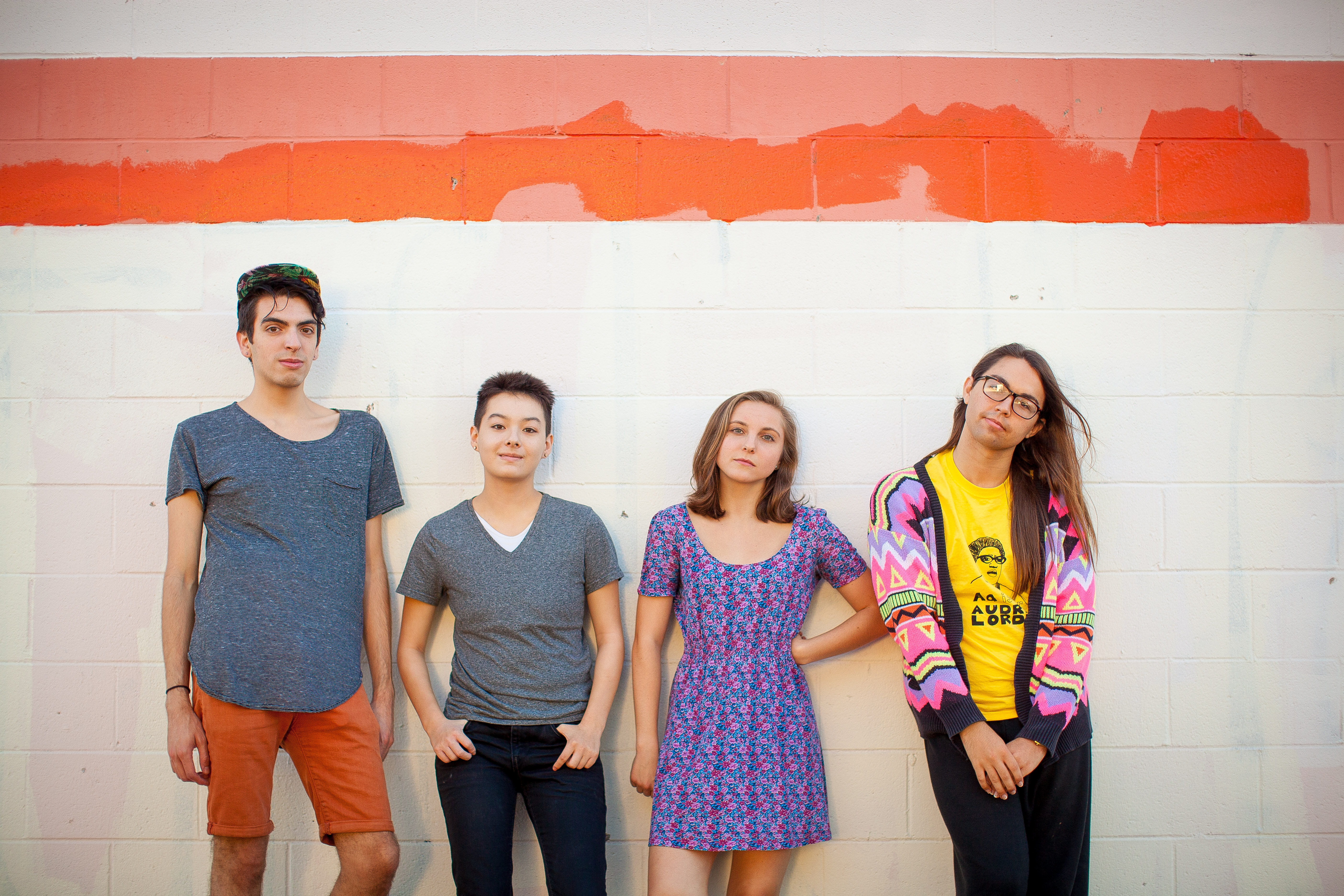group of people leaning against a wall