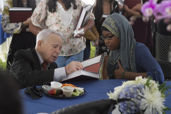 Holocaust survivor signing a book for a woman