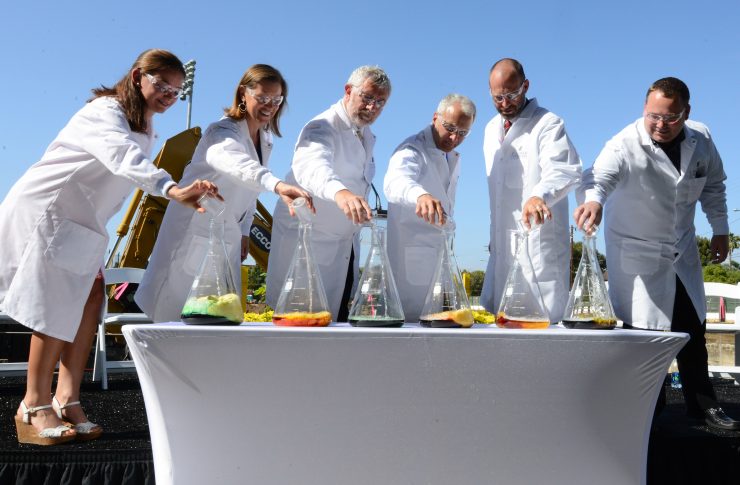 People pouring chemicals into beakers