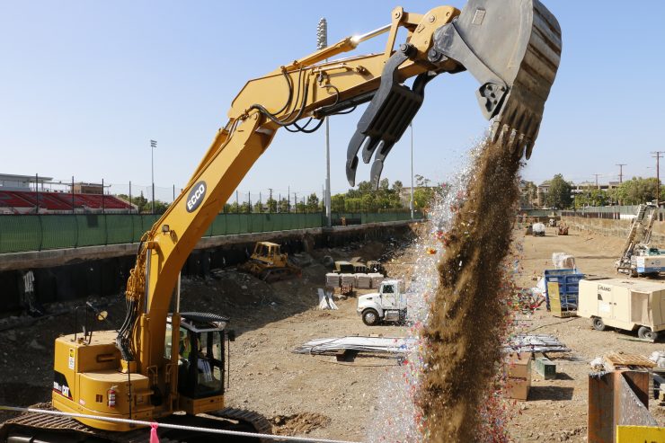 Backhoe pouring dirt