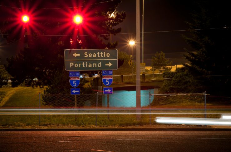 A highway sign points to Interstate 5 North to Seattle and Interstate 5 South to Portland.
