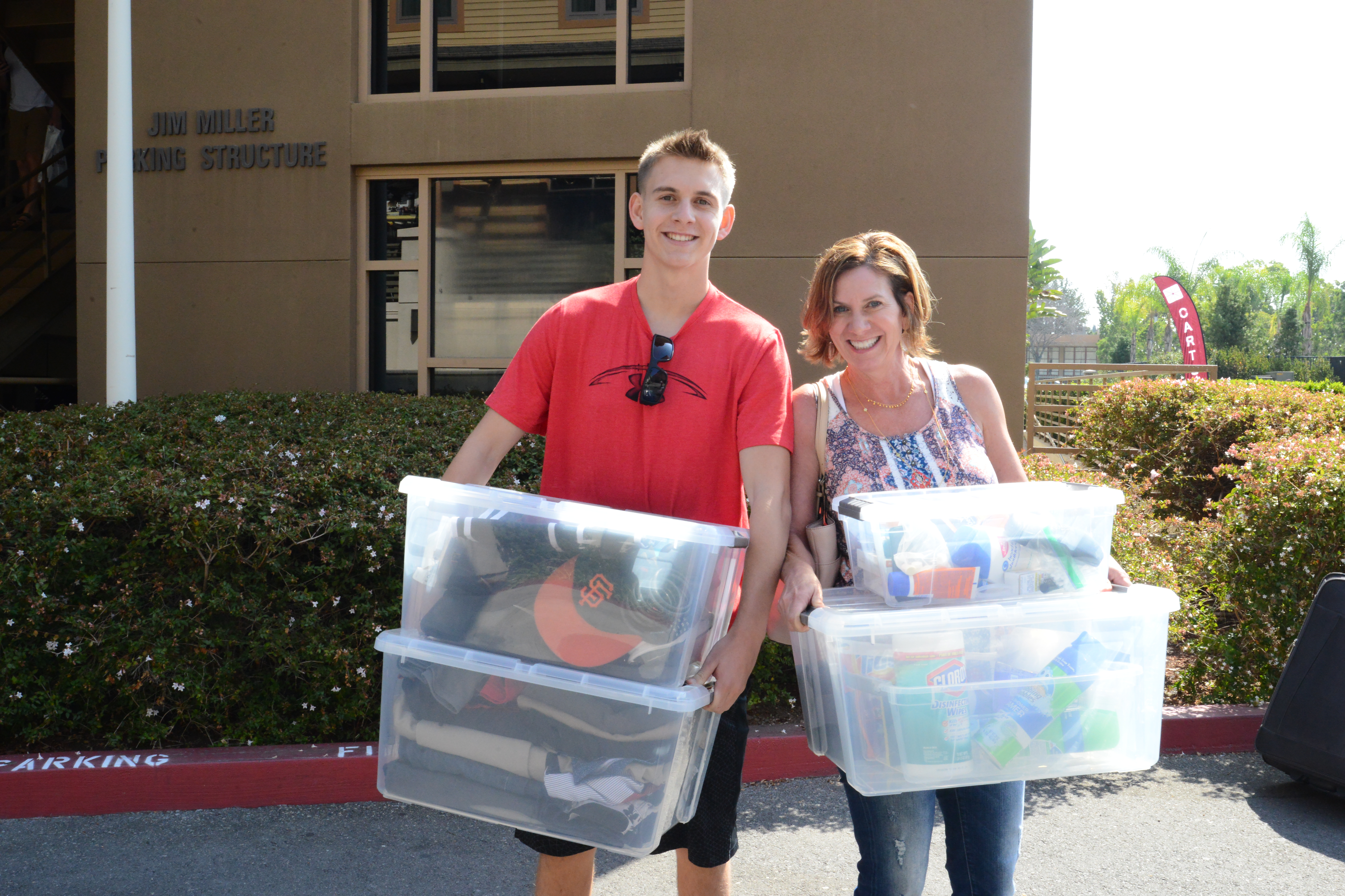 Young man and mother carry boxes
