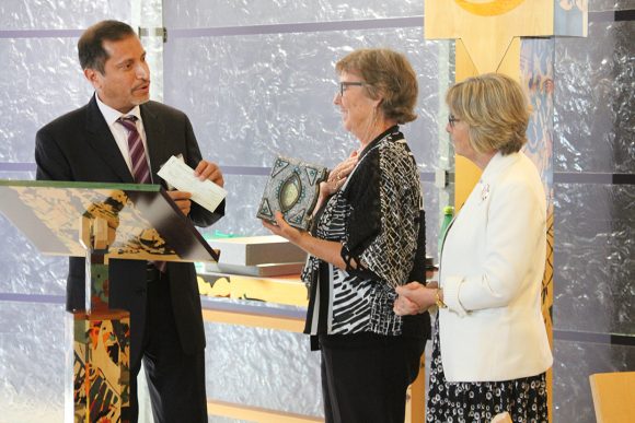 Leatherby Libraries Dean Charlene Baldwin (center) and Dean of the Chapel Rev. Gail Stearns accept a Quran and a check for $5,000 from OC businessman Fareed Farukhi.