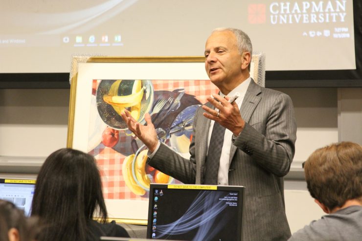 President Emeritus and Professor Jim Doti teaches statistics with the aid of a painting from Chapman's Hilbert Museum of California Art.