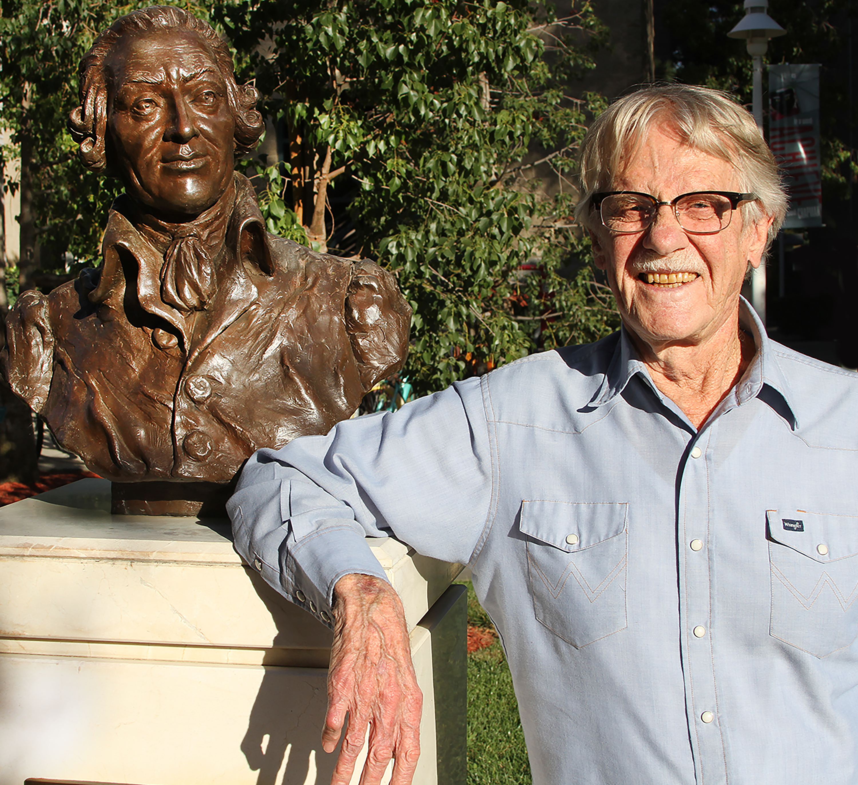 Nobel laureate Vernon L. Smith, Chapman professor of economics and law, poses with the bronze bust of moral philosopher Adam Smith on the Chapman campus. A $15M gift will establish the Smith Institute for Political Economy and Philosophy at Chapman, honoring both Smiths.