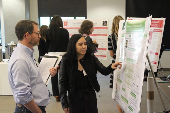 Christine Navarro explains her poster to Dr. Jason Keller