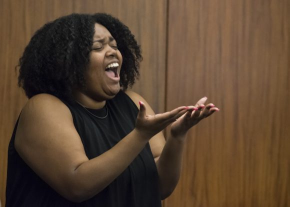 woman singing with hands out front