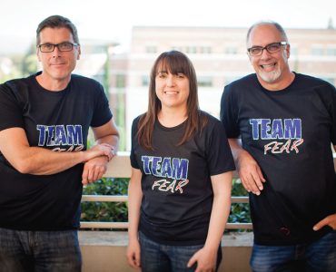 three professors at a railing posing