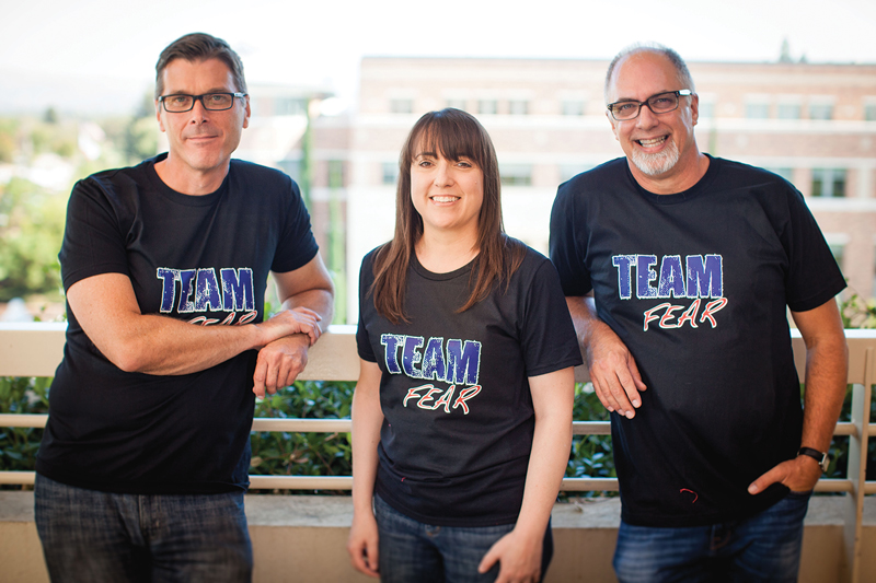 three professors at a railing posing