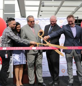 School of pharmacy happily cutting ribbon