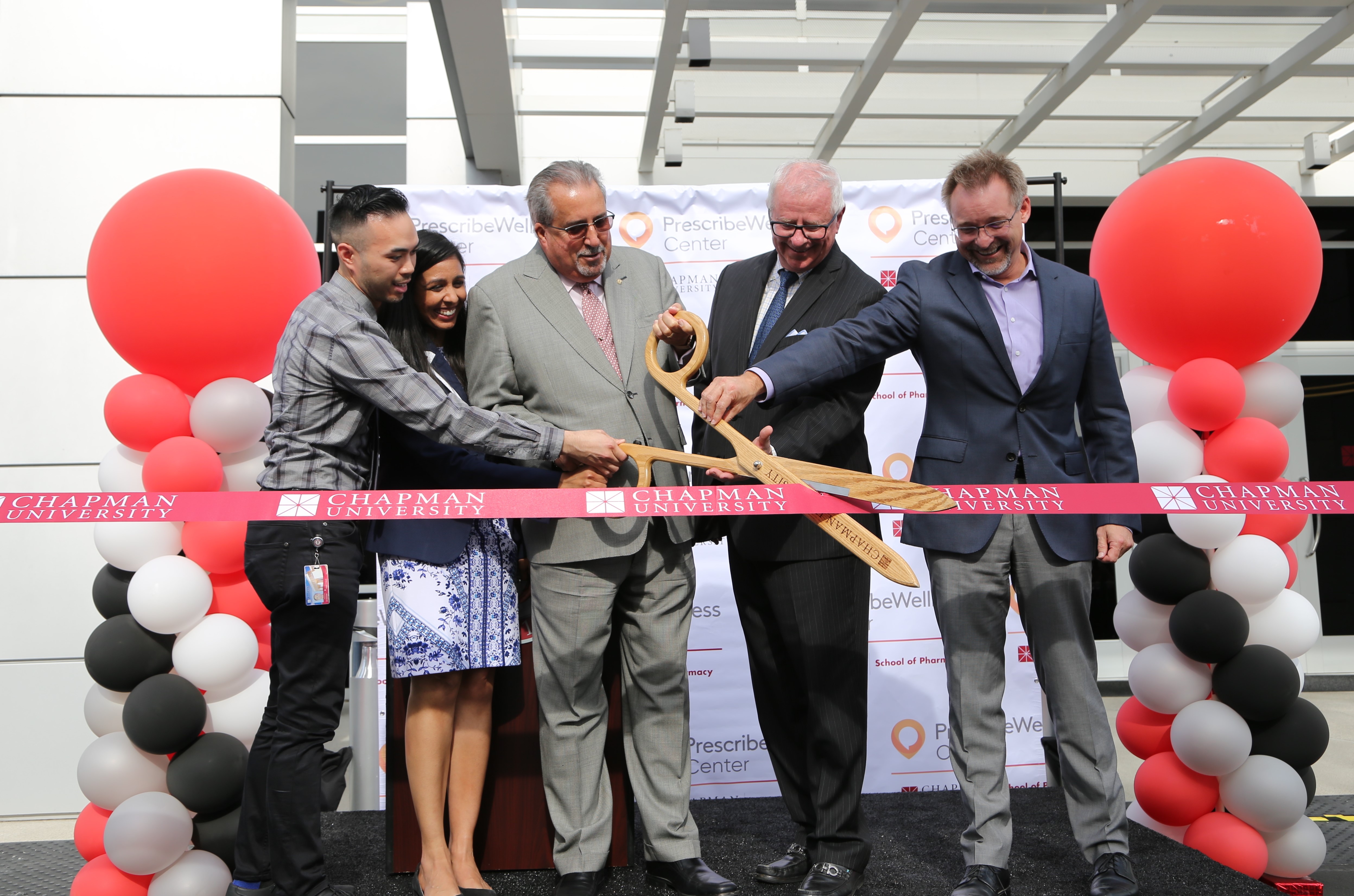 School of pharmacy happily cutting ribbon