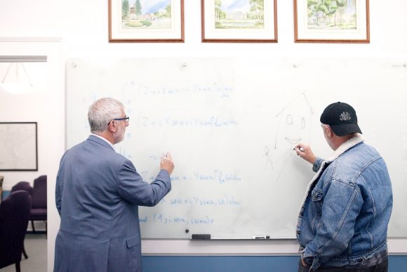 Chapman President Daniele Struppa writing on white board with twin 