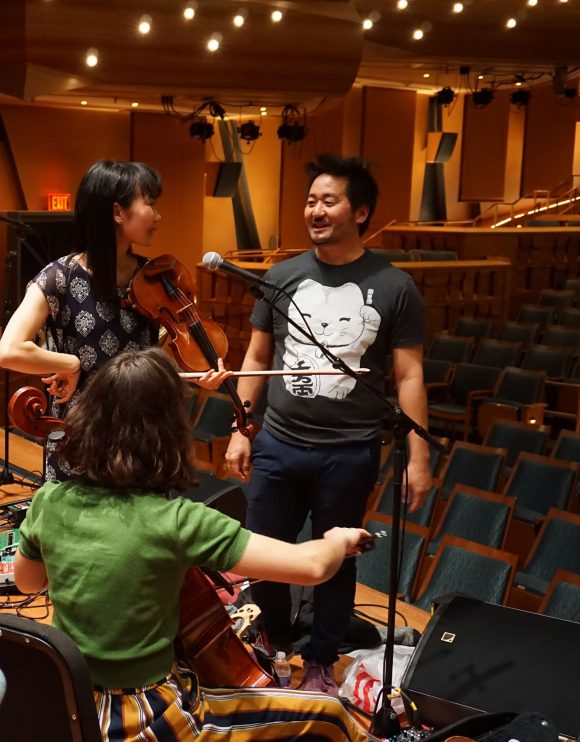 Students Lisa Yoshida and Bella Pepke, with violin and cello, learn how to operate loop pedals from Kishi Bashi.