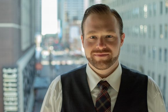 man wearing vest and tie smiling