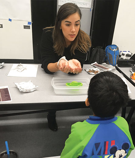 Graduate Student Maribel Barrios Teaching Math to a child at Salk Elementary