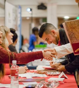 Students shake the hands of potential employers at the career fair.