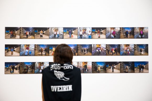 Woman gazes at photographs. 