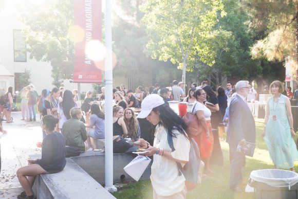 People gather outside on a sunlight afternoon on Chapman's campus. 