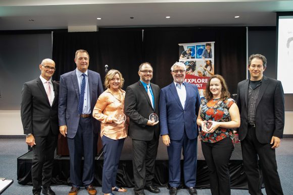 Faculty and administrators pose with awards