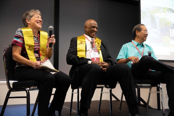 Karen Wilkinson, Frank Franklin, Cliff Ishigaka seated on stage laughing