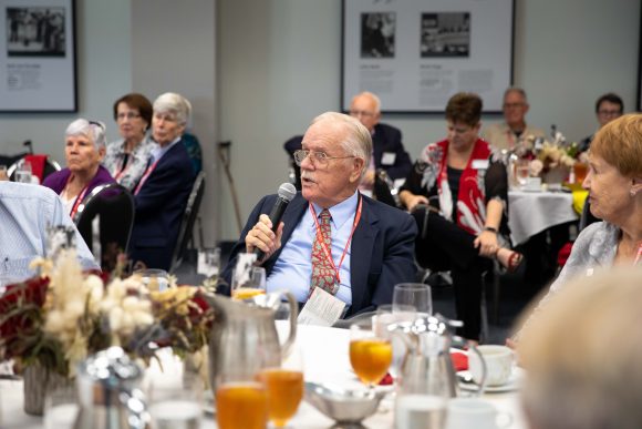 man at luncheon table with microphone