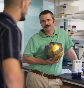 Biological sciences student Alex Drives '21, left, talks with Carter Berry, Ph.D, about equipment Drivas helped design to advance Berry's plant research. Photo by Dennis Arp.