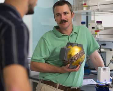 Biological sciences student Alex Drives '21, left, talks with Carter Berry, Ph.D, about equipment Drivas helped design to advance Berry's plant research. Photo by Dennis Arp.