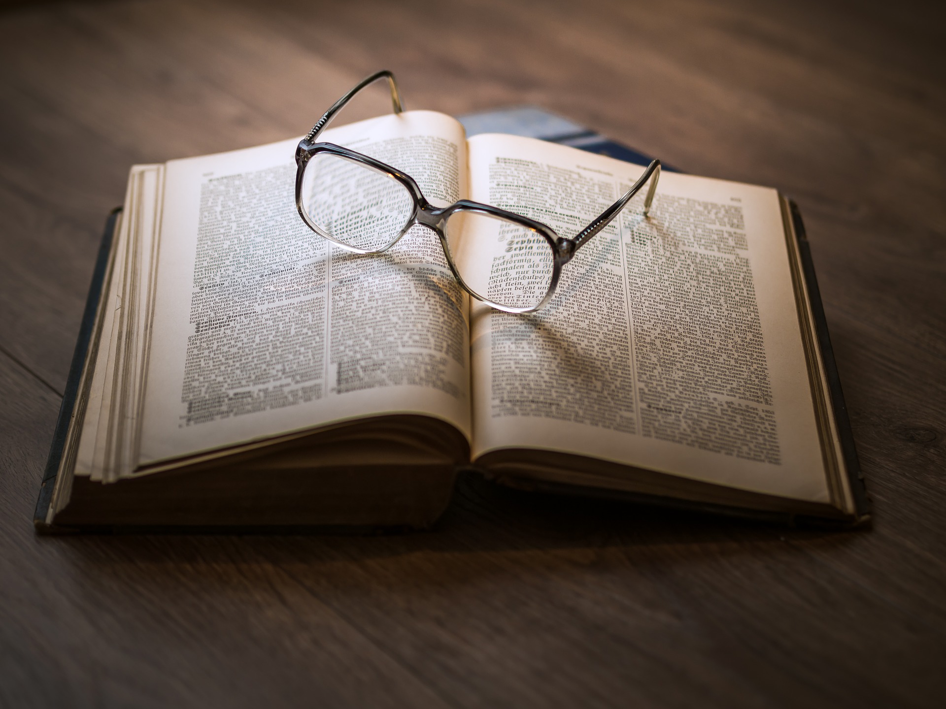 Book on table with glasses.