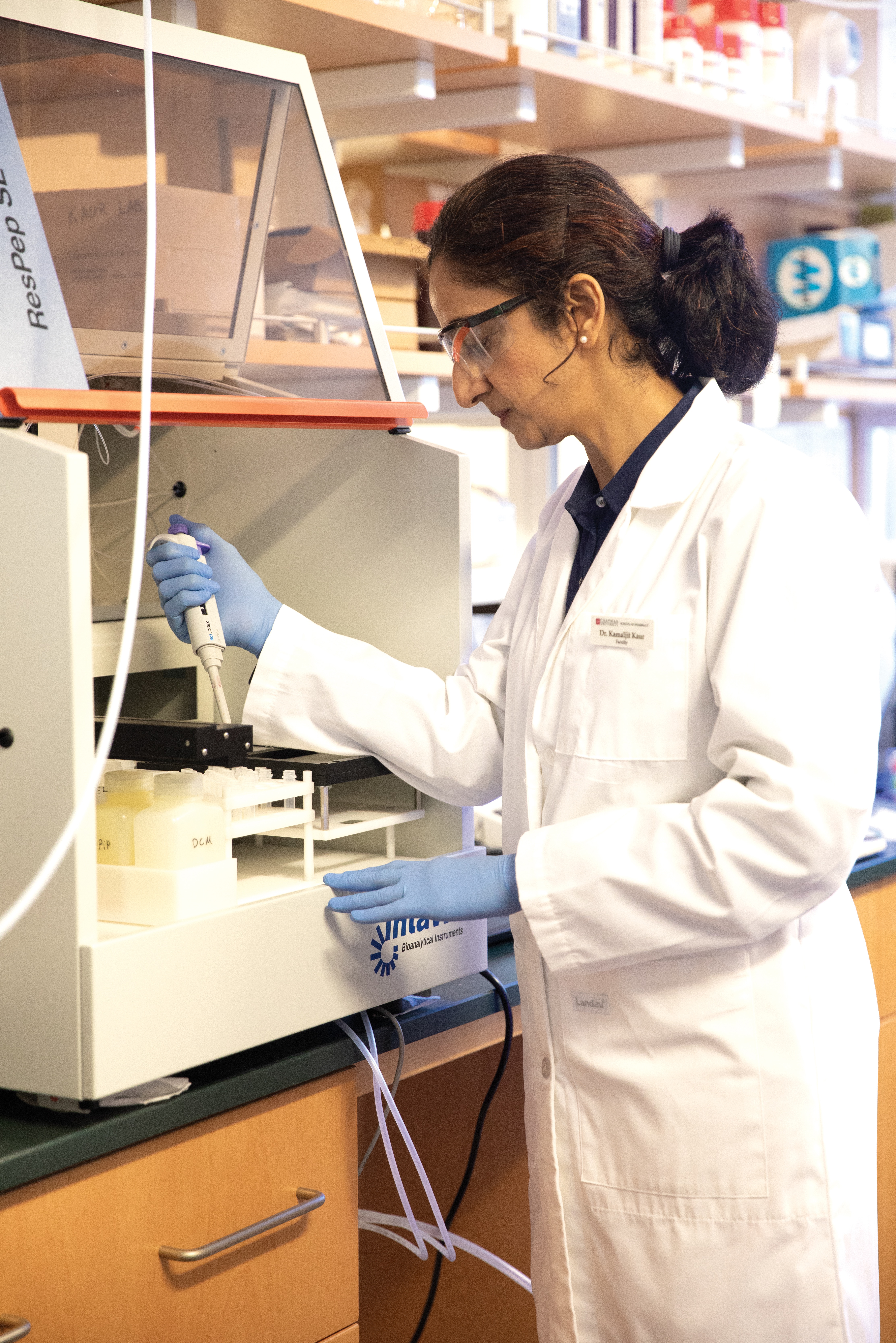 Kamaljit Kaur looks through a microscope